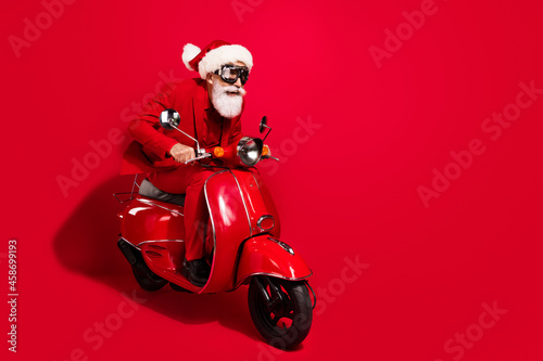 Profile photo of crazy santa claus ride motorcycle fast wear goggles x-mas hat suit on red color background