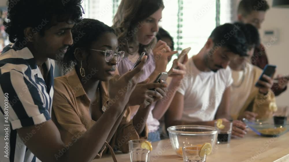 Big group of Young diverse multiracial people sitting together and looking at their phones - Social media concept and addiction, millennials lifestyle Big group of Young diverse multiracial people sitting together and looking at their phones - Social media concept and addiction, millennials lifestyle