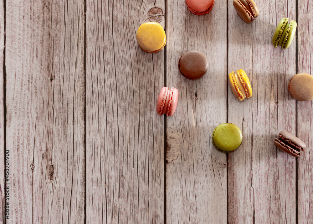 Dessert of French macarons in pastel colors on wood. Copy space. Selective focus.