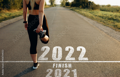 Sports girl who stays at the starting line towards the year 2022, leaving behind the year 2021. The new year 2022 with new ambitions, plans, objectives and visions. photo