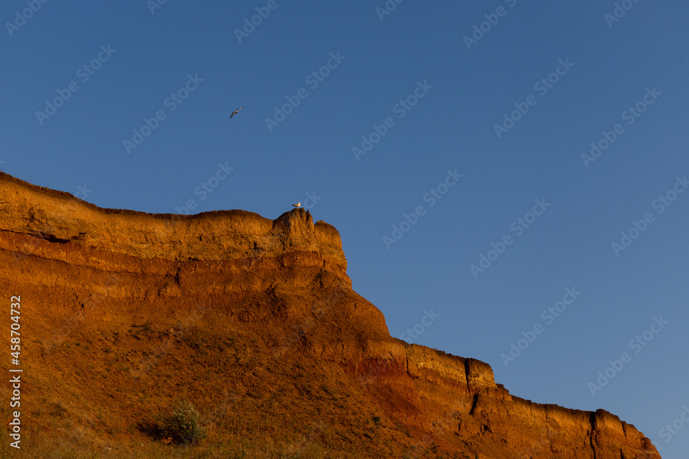 Geology. Desert landscape. Panorama view of the sandstone formation, the rocky cliffs, sand. Background or texture of sandy cliff on the coast, orange limestone Geology. Desert landscape. Panorama view of the sandstone formation, the rocky cliffs, sand. Background or texture of sandy cliff on the coast, orange limestone