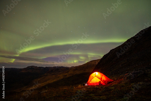tent in the mountains and a spiral of green light