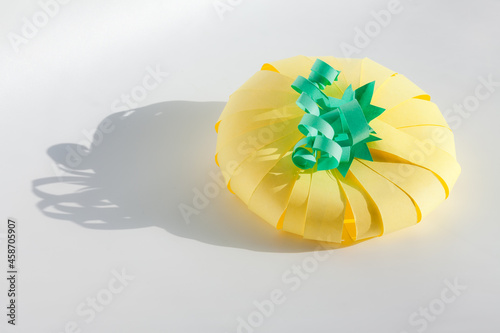 Yellow color pumpkin made from paper on gray background