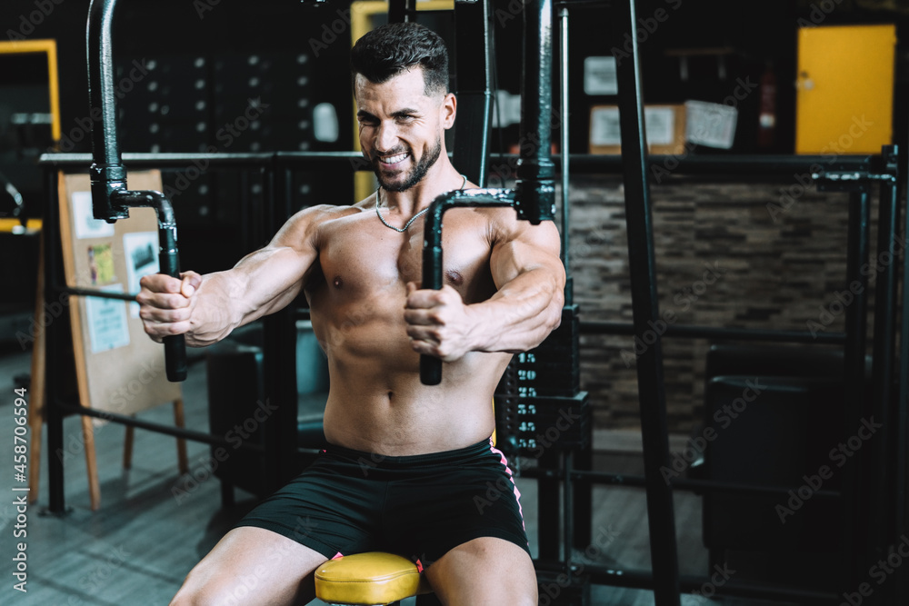 Portrait of a man exercising with weights using a machine in a gym Portrait of a man exercising with weights using a machine in a gym