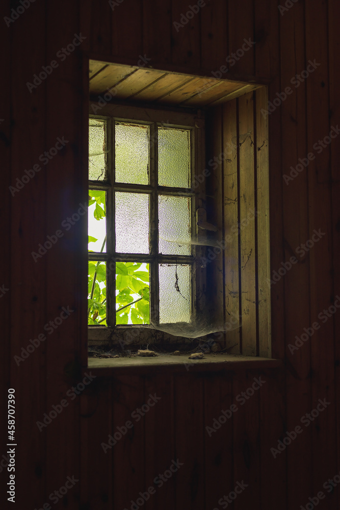 Light through an old dilapidated window with cobwebs. Light through an old dilapidated window with cobwebs.