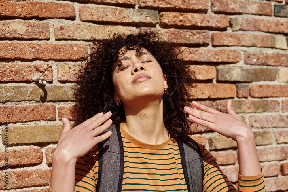 Young woman facing upwards with her eyes closed