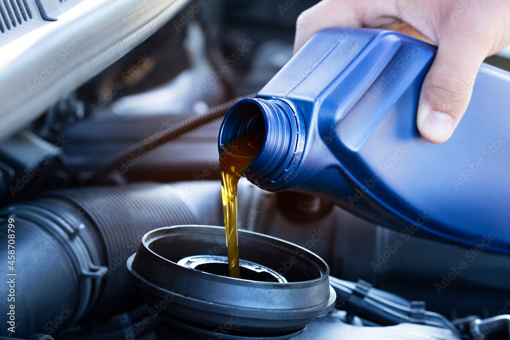 Motor oil pouring. Refueling and pouring oil quality into the engine