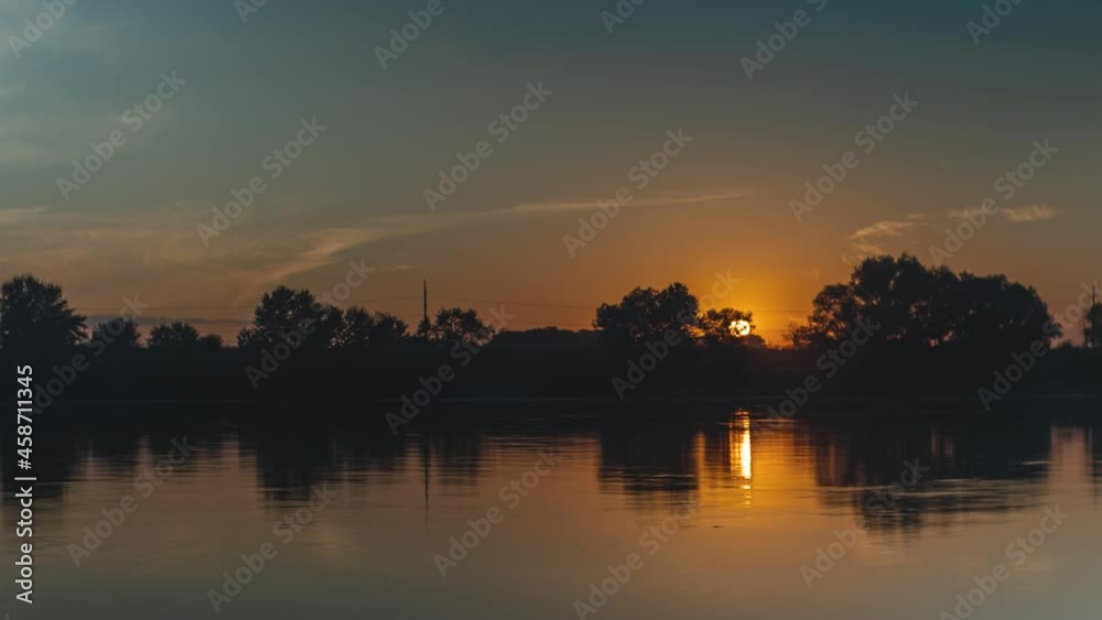 Sunset over the river. Trees and clouds are reflected in the water. Smoothly zooming in and out of the camera. A timelapse of nature Sunset over the river. Trees and clouds are reflected in the water. Smoothly zooming in and out of the camera. A timelapse of nature