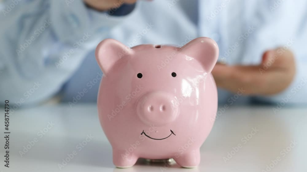 Close up of woman hand putting euro money in piggy bank to save. Close up of woman hand putting euro money in piggy bank to save.