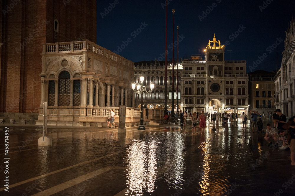 Naklejka premium tourists witness the phenomenon of high tide in Piazza San Marco in Venice 