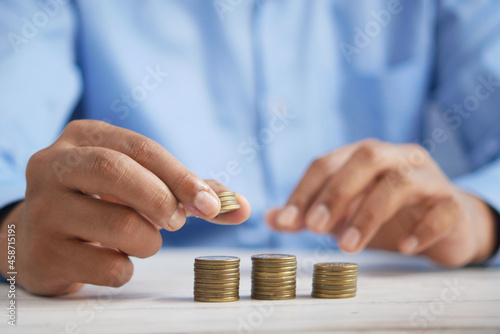 man's Hand putting stack of coins photo