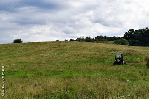 Ciągnik rolniczy na zielonej łące.