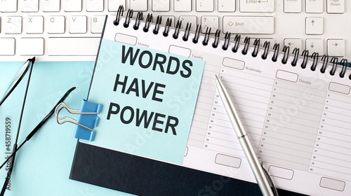 Photos WODS HAVE POWER text on blue sticker on planning and keyboard,blue background
