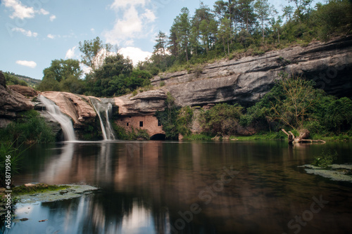 long exposure of a waterfall with lake and a house