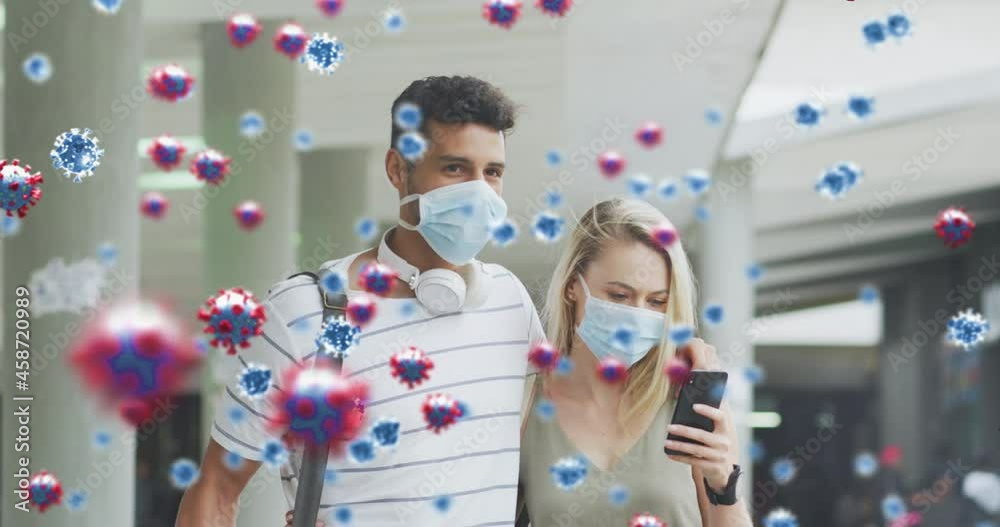 Animation of virus cells over aucasian couple wearing face masks using smartphones Animation of virus cells over aucasian couple wearing face masks using smartphones