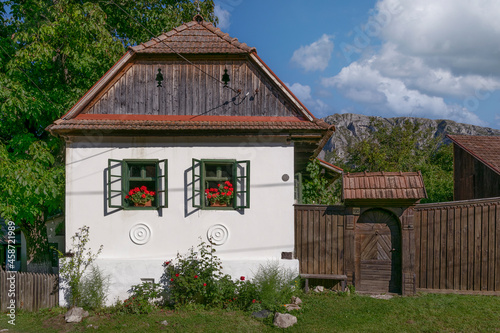 rural house with flower at windows in a mountain village Rimetea Romania photo