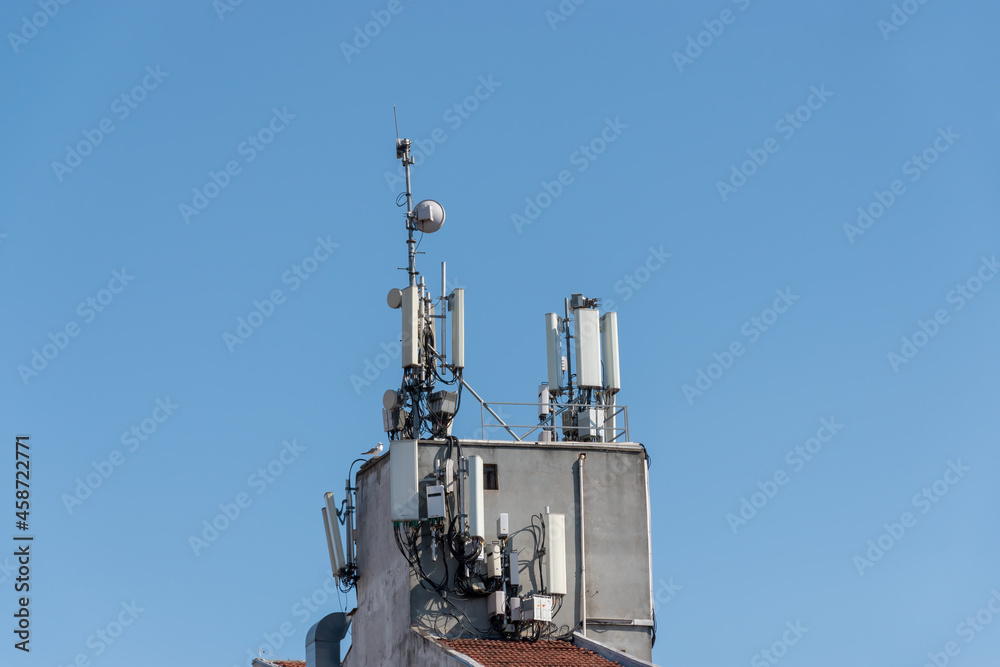 GSM antenna on the building roof front of the blue sky