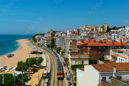 An electric train arrives at the station in a seaside town