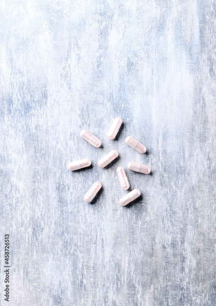 Carnitine capsules. Concept for a healthy dietary supplementation. Wooden background. Soft focus. Top view. Copy space. Carnitine capsules. Concept for a healthy dietary supplementation. Wooden background. Soft focus. Top view. Copy space.