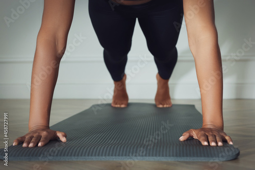 Young woman doing plank exercise indoors, closeup