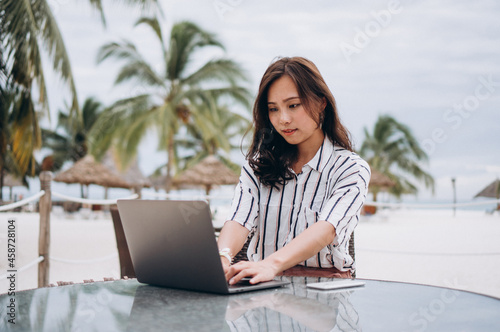 Asian woman working on laptop on a vacation © Petro