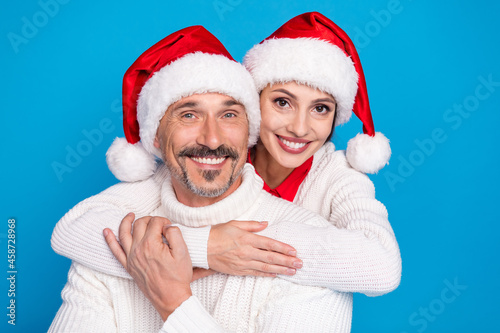 Portrait of attractive cheerful sweet couple hugging wearing festal look isolated over bright blue color background