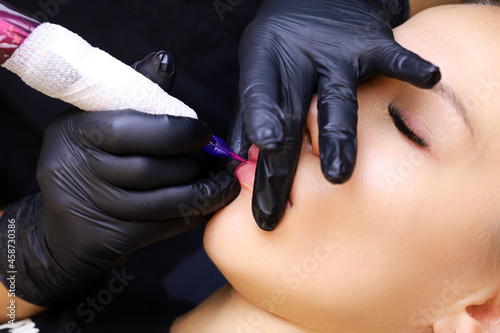 close-up of the master fills the lower part of the lip with a tattoo
