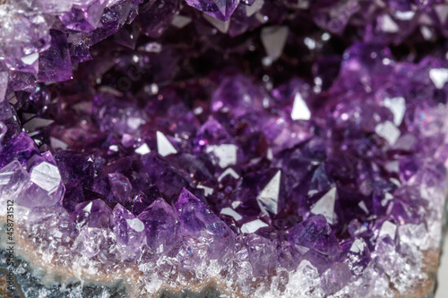 Macro Mineral Stone Amethysts in the rock on a white background