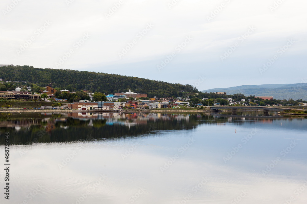 Panoramic view of a small town and its reflection in a body of water during a grey morning, Gaspé, Quebec, Canada