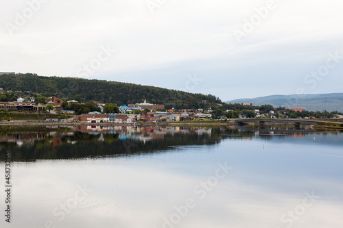 Panoramic view of a small town and its reflection in a body of water during a grey morning, Gaspé, Quebec, Canada