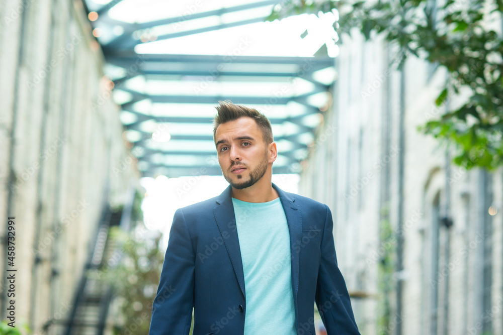 A young successful businessman is working outdoor using smartphone. Man in a casual wear. Business, freelance and remote work. A young successful businessman is working outdoor using smartphone. Man in a casual wear. Business, freelance and remote work.
