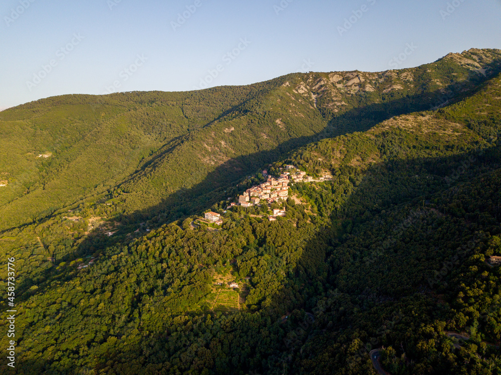 Aerial Drone Panorama of mountain old town Marciana on the islands of Elba Italy with green trees and the mediterranean sea ocean in the background