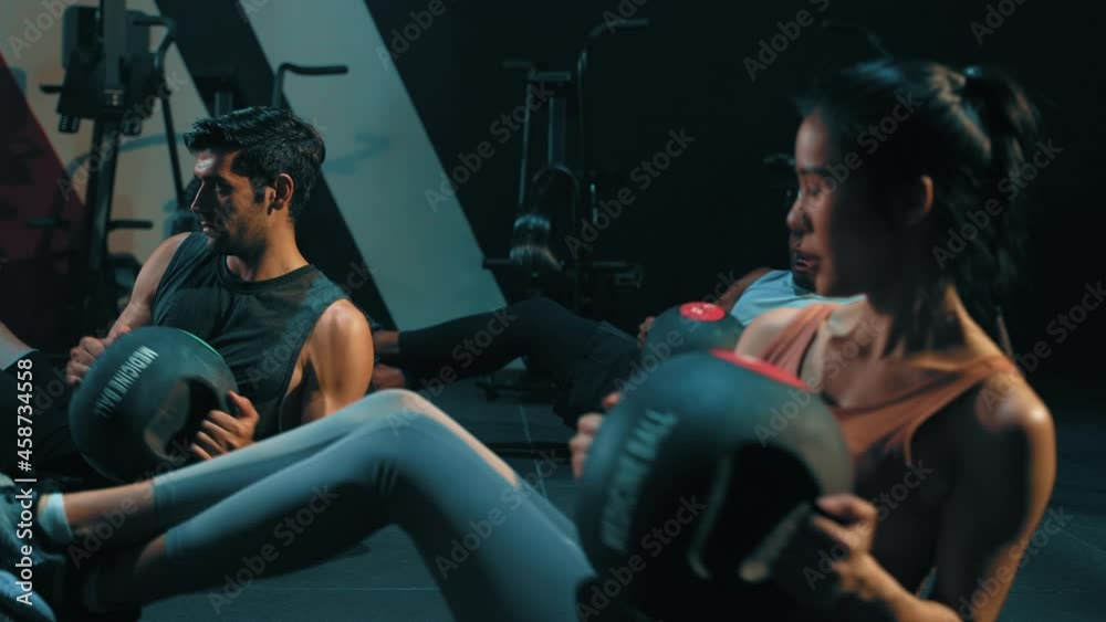 Group of multi ethnic people doing kettlebell twist, cardio. Strength training workout at gym fitness center club. Exercise indoor with sport equipment. People lifestyle recreation. Strong team.