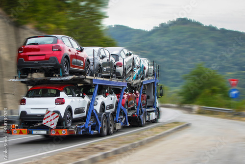 Truck carrying new cars. Production, export and transportation of concept vehicles.No logo or brand. Moving. Panning efect.