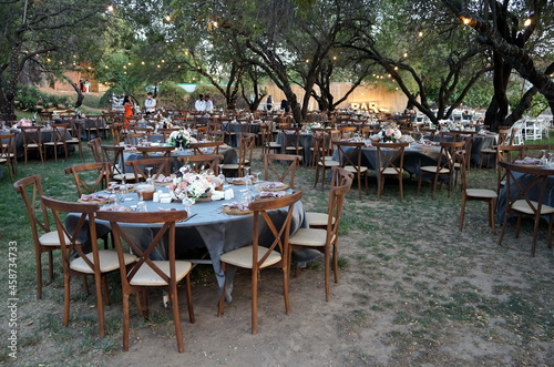 Runde gedeckte Tische mit blauen Tischdecken und Blumenschmuck für eine türkische Hochzeit im Sommer in einem Park in Güzelbahce in der Provinz Izmir am Ägäischen Meer und Mittelmeer in der Türkei photo