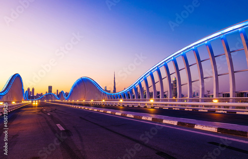 Beautiful view of Meydan Bridge in Dubai. Modern artistic bridge in Dubai. Night architectural shot of a bridge with curvy blue lights. © Sudarsan Thobias