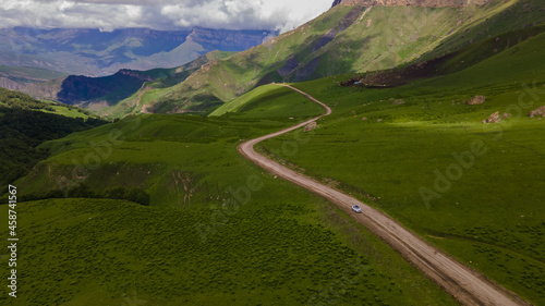 Car Moving among Green Hills and Forest. Aerial View