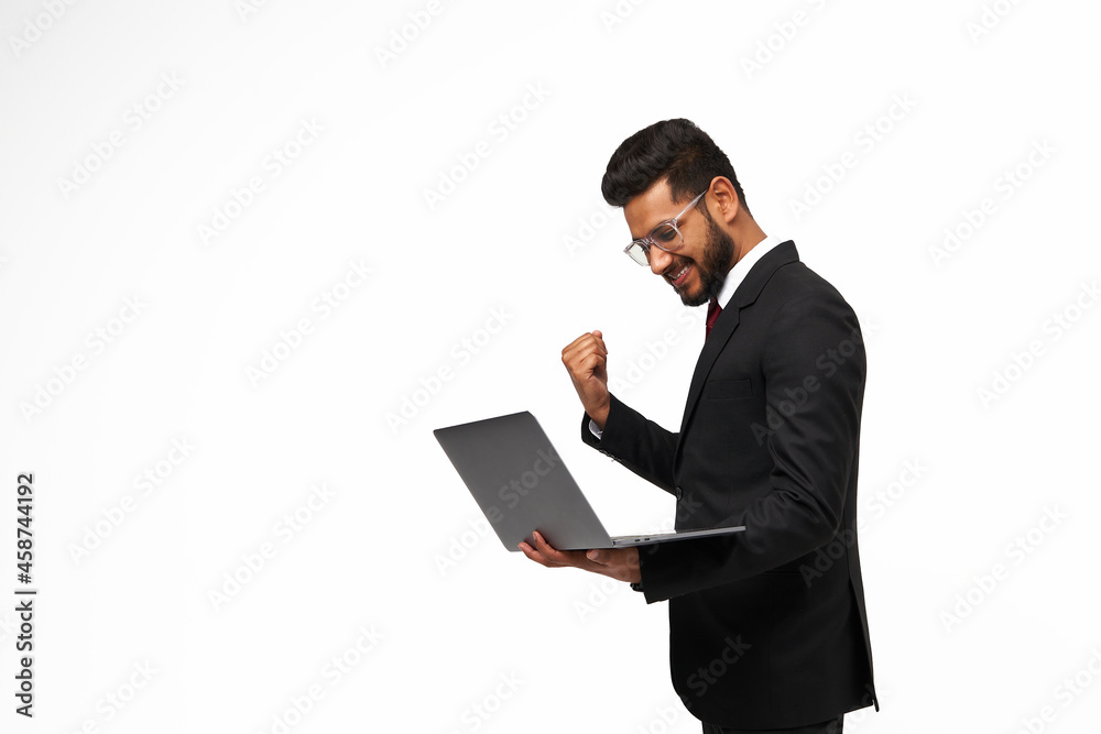 Handsome mager using his laptop and celebrating the victory on white isolated background Handsome mager using his laptop and celebrating the victory on white isolated background
