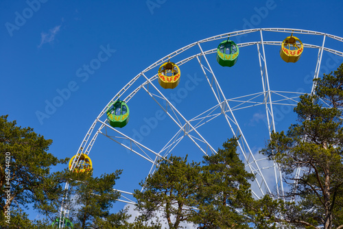 Colorful booths on a Ferris wheel against a clear blue cloudless sky. Ferris Wheel is in the park
