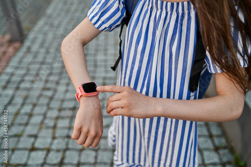 Close up pink smartwatch on hand of little girl