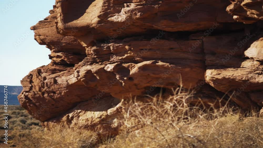 Panning shot of huge red sandstone rock in the middle of a desert. Closeup Panning shot of huge red sandstone rock in the middle of a desert. Closeup