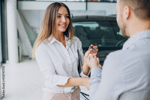 Business man buying a new car in a car showroom