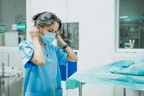 Veterinarian putting on sterile mask in operating room photo