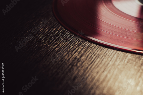 vinyl pink record on wooden table. close-up, macro.
