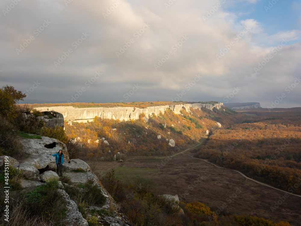 Happy girl looking at the camera. Beautiful views of mountain on a sunny autumn day. The cave city of Eski-Kermen in the Bakhchysarai district, Crimea