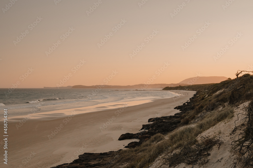 A deserted beach and headland during sunset. A deserted beach and headland during sunset.