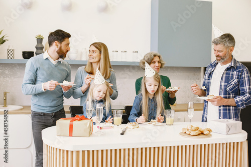 Family celebrating birthday of their grandmother in the kitchen