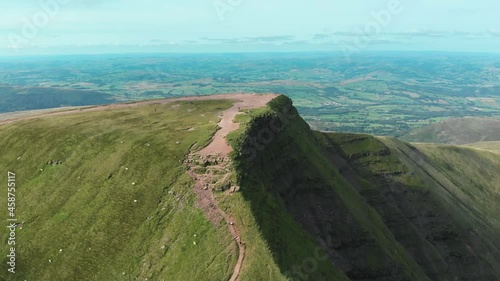 Aerial drone shot of hikers atop Pen Y Fan and Cribyn mountain peaks in Brecon Beacons National Park, Wales photo