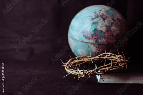the crown of thorns of Jesus on  the holy bible with blurred world globe on blac Fototapet