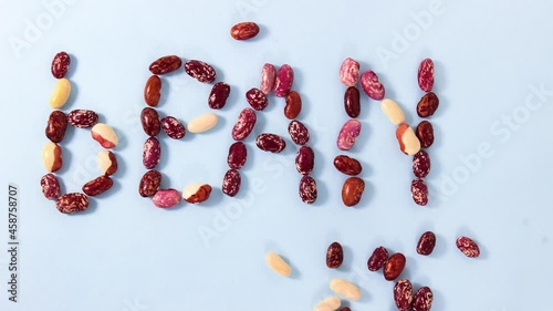 Stop motion animation. Cartoon. The ripened string beans move along the surface and line up in the word BEANS. Top view.
